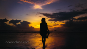 woman alone on shore during sunset