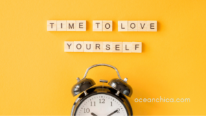 Time to love yourself with a clock underneath words on a yellow background